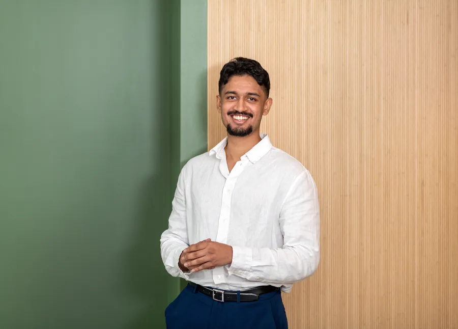 Sanjeth smiling, in a white linen shirt
